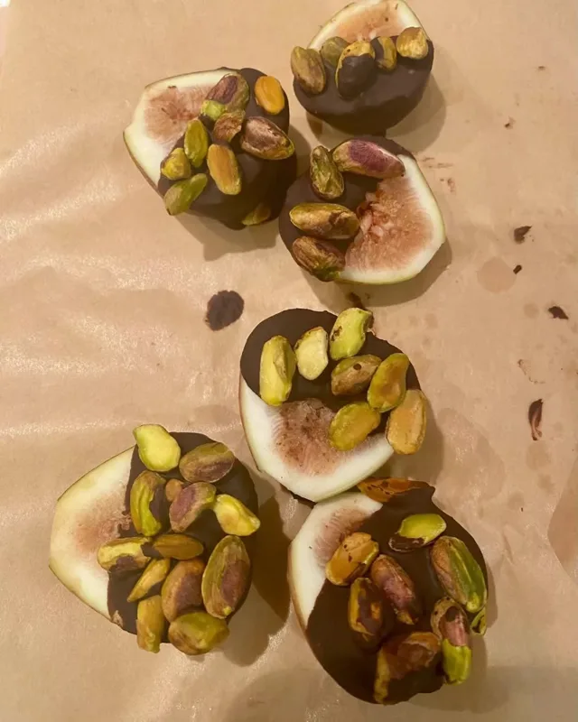 Fig slices dipped in dark chocolate with pistachios